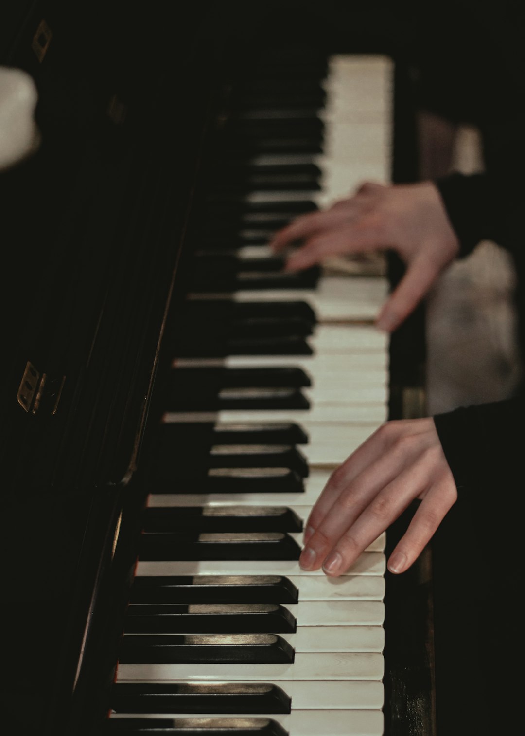 about-img a-person-playing-a-piano-in-a-dark-room-hwhzcata-fm
