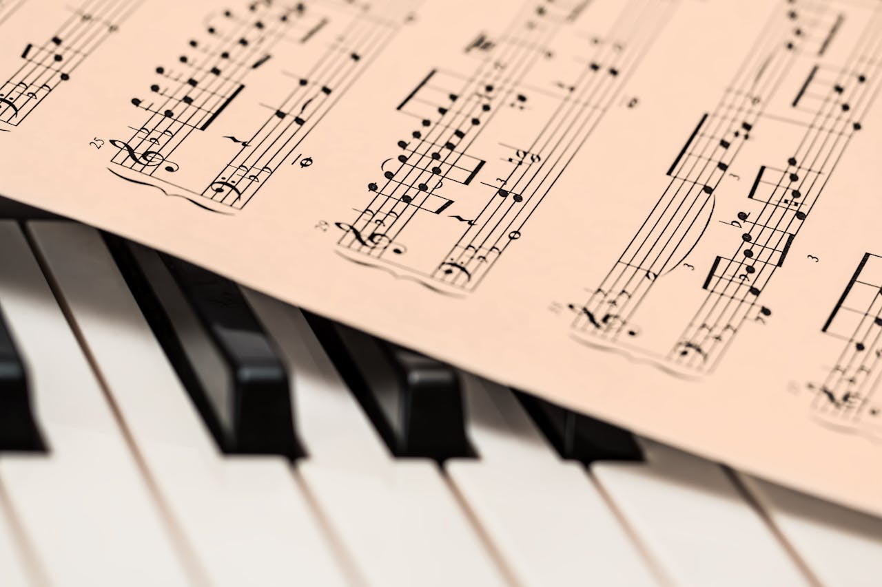 gallery-6 Black and white piano keys with a sheet of classical music creating a harmonious composition.
